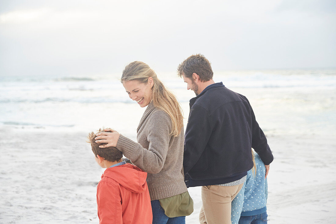 Smiling family walking on winter beach