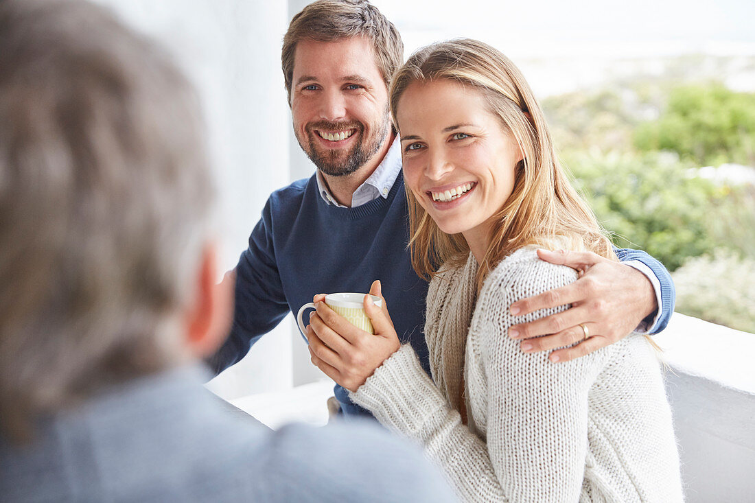 Smiling couple hugging and drinking coffee