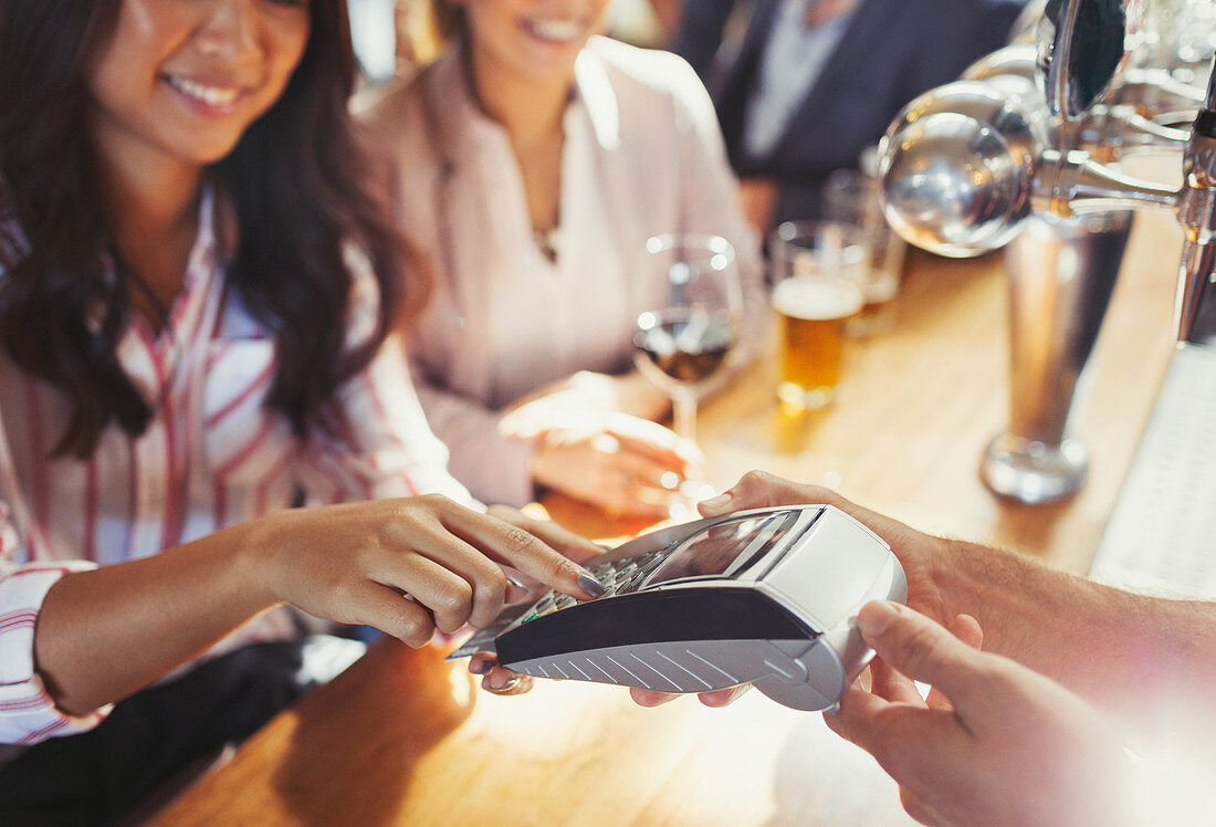 Woman paying bartender using credit card