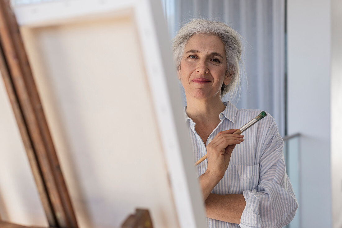 Portrait confident mature woman painting