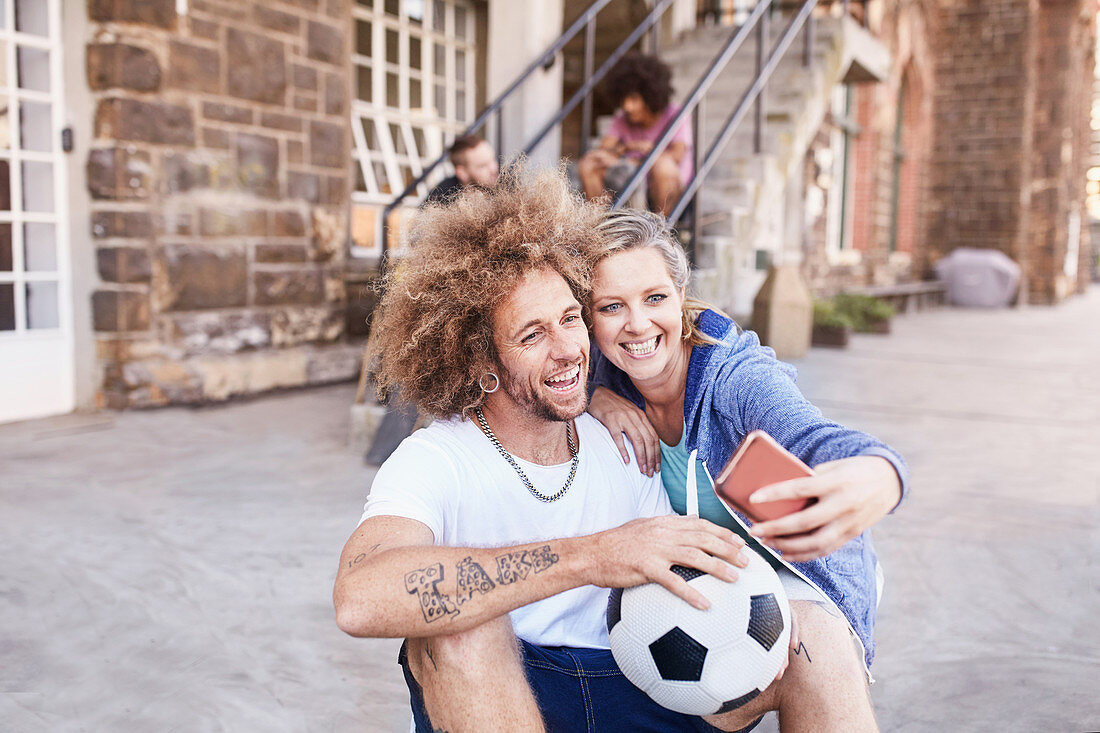 Couple with soccer ball taking selfie