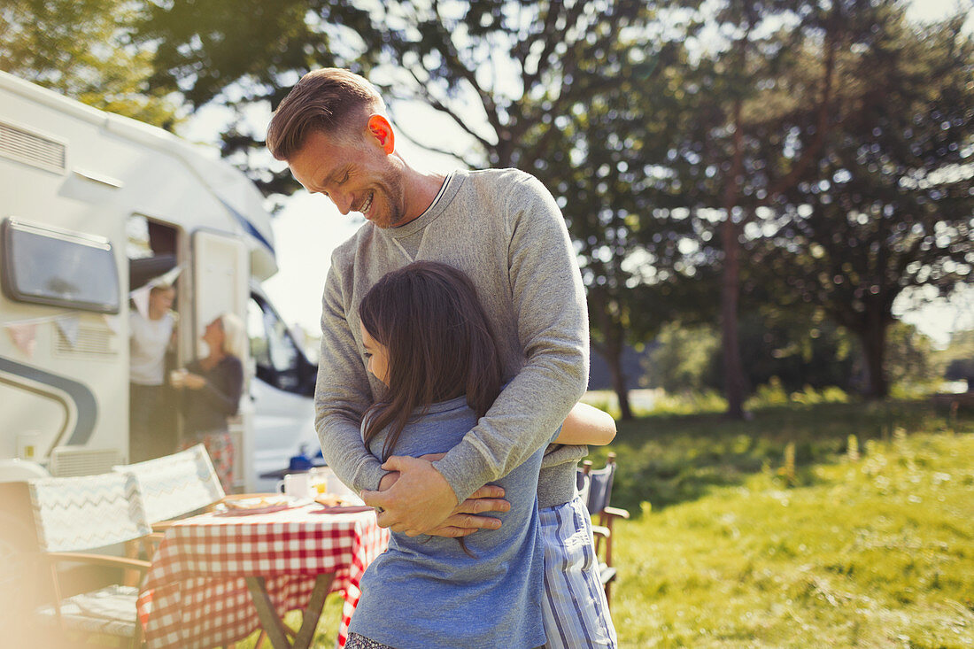 Smiling father hugging daughter