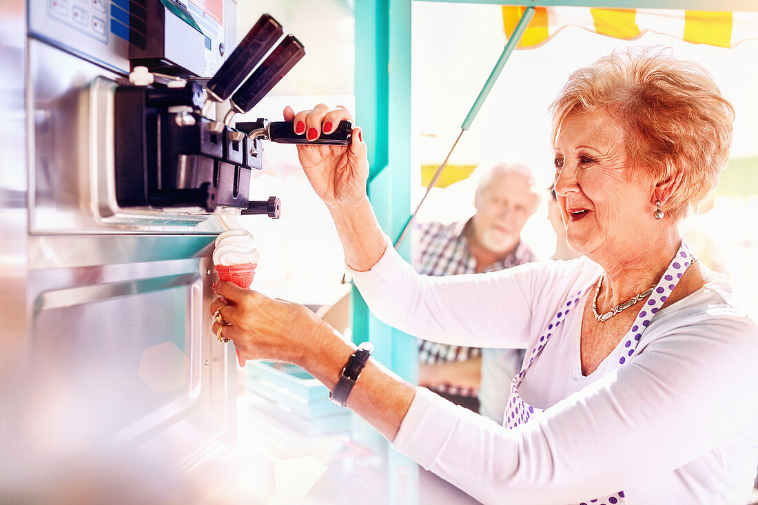 Senior female business owner serving ice cream