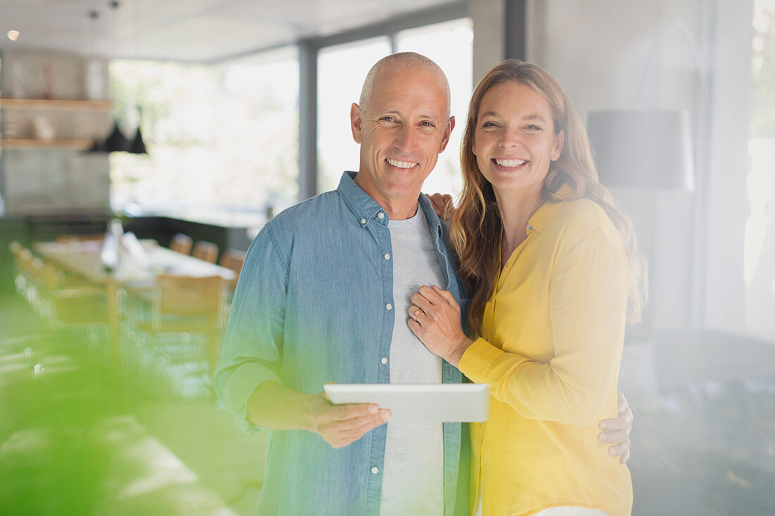 Portrait smiling couple with digital tablet