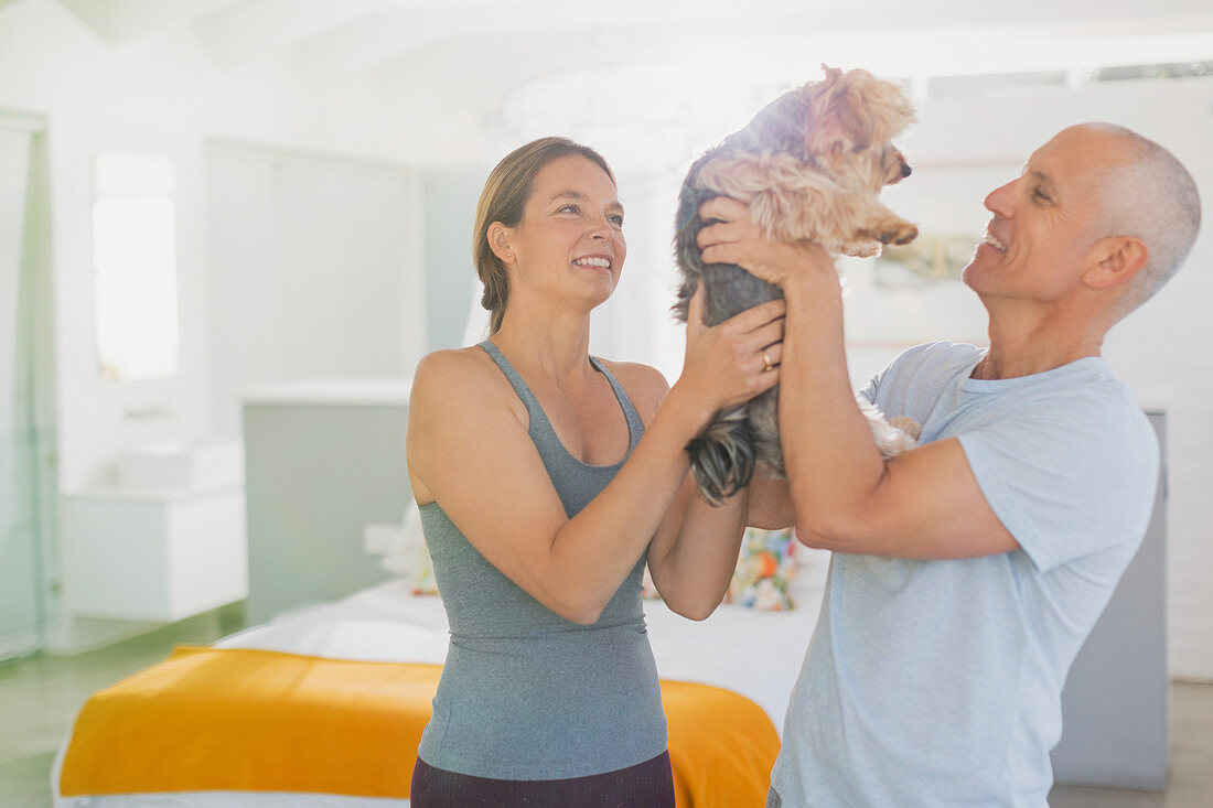 Mature couple playing with dog