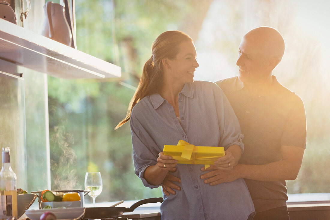 Smiling husband surprising wife with gift