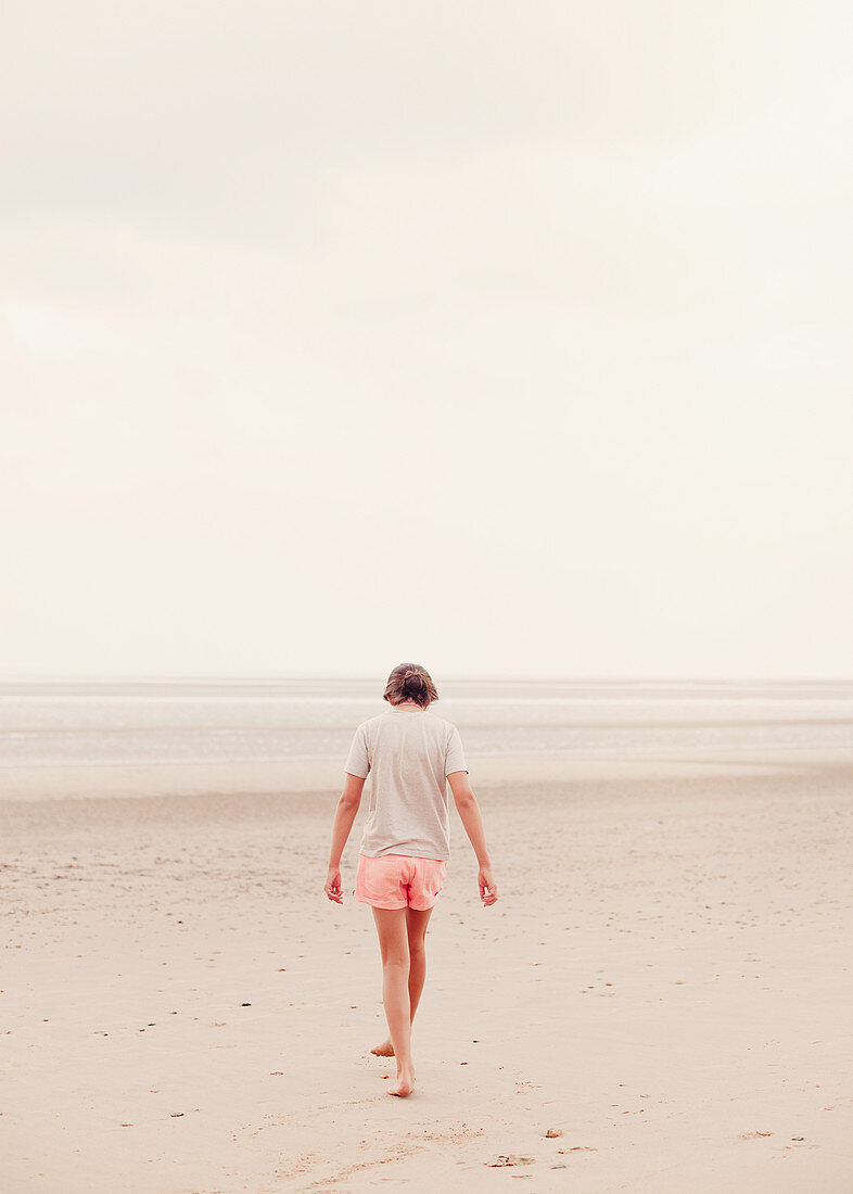 Teenage girl walking in sand