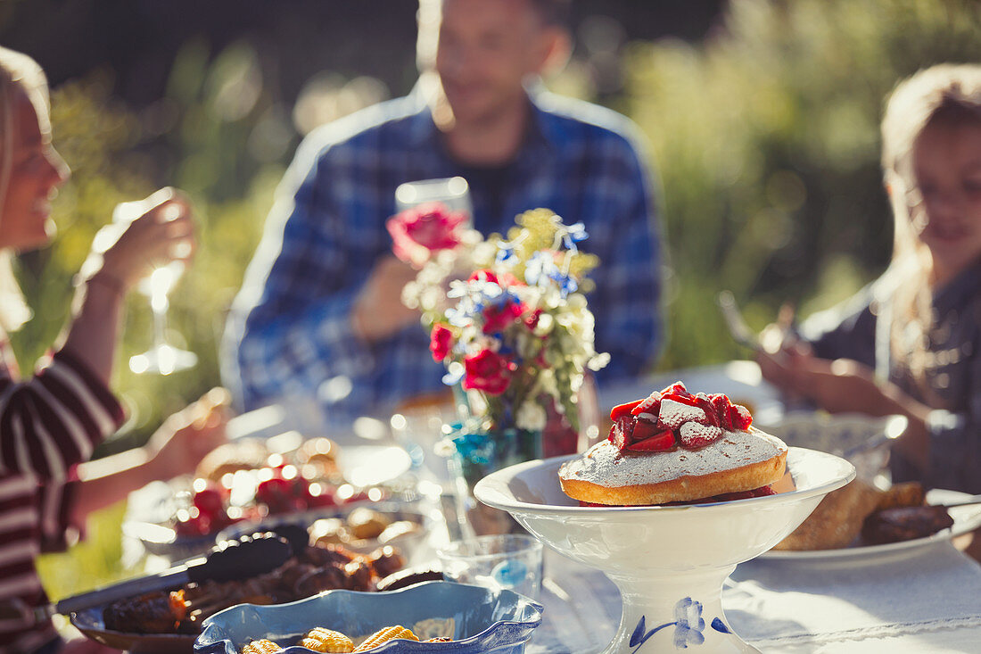 Family enjoying strawberry cake