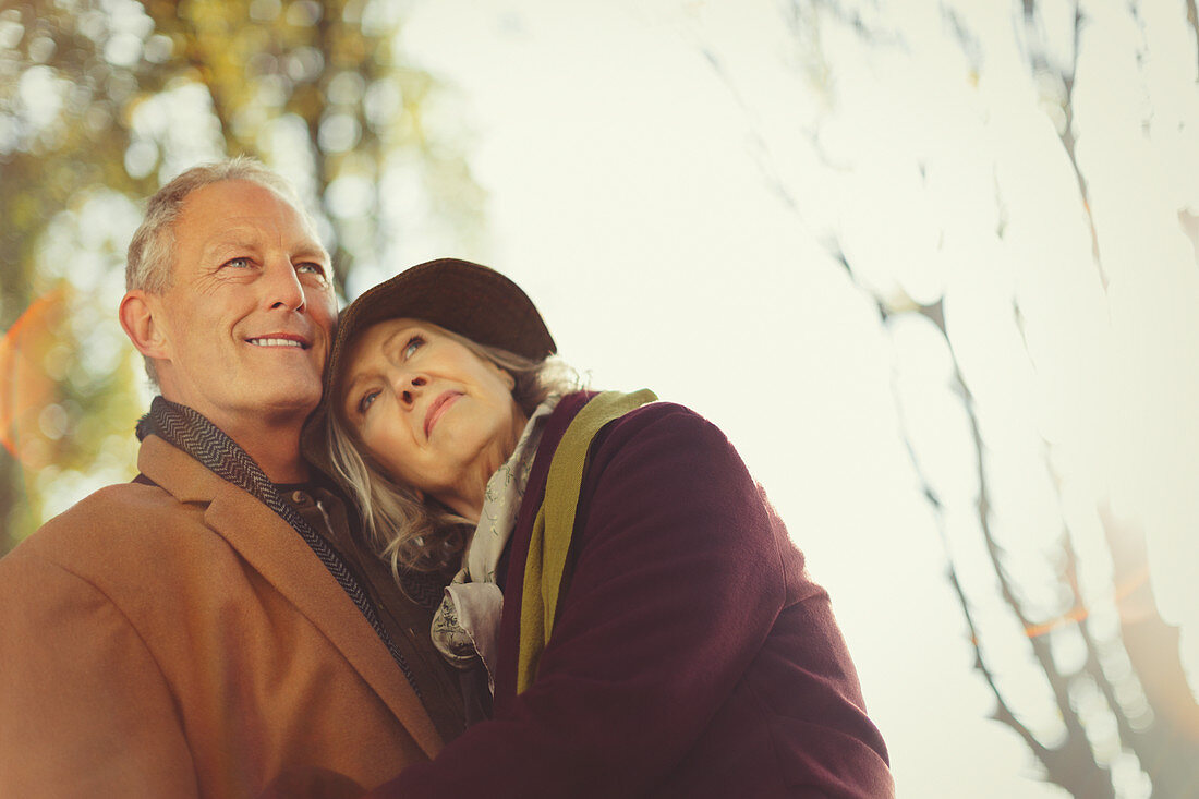 Affectionate, serene senior couple in autumn park