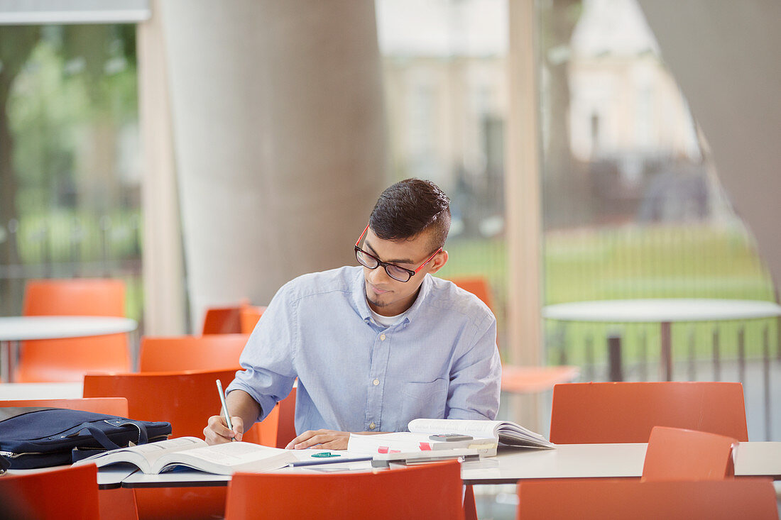 Male college student studying at table
