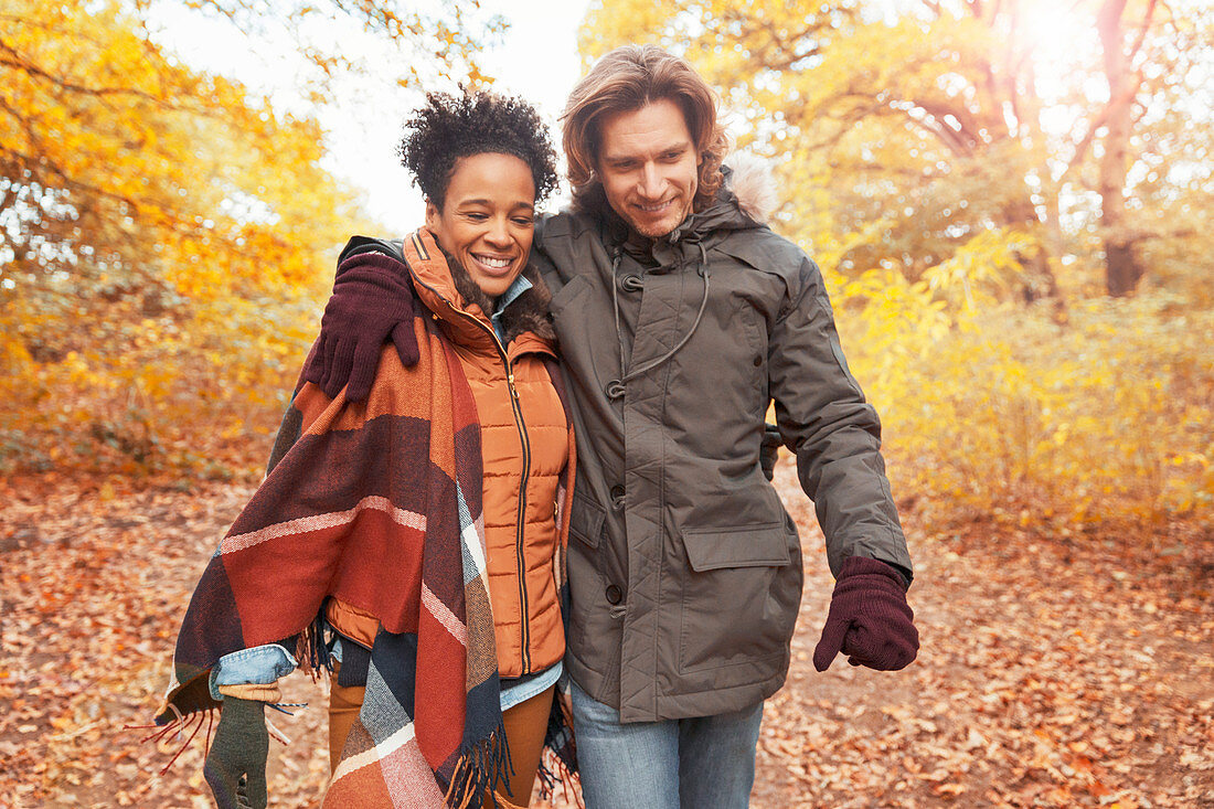 Affectionate couple walking on path in autumn park