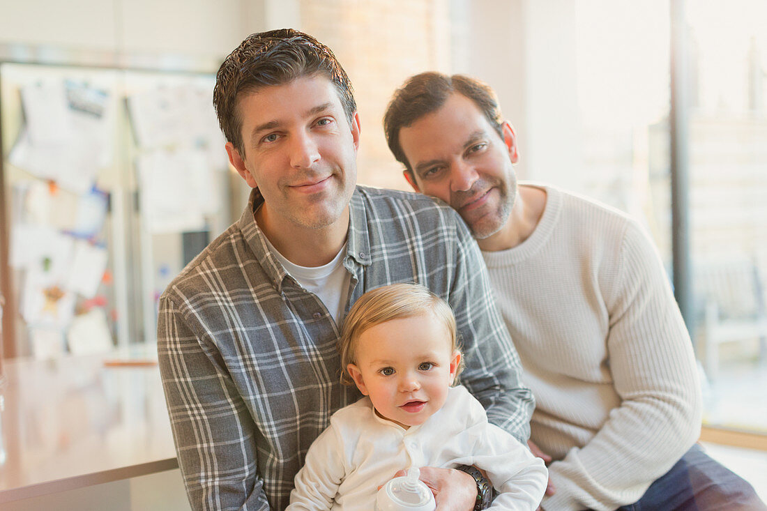 Portrait smiling male gay parents with baby son