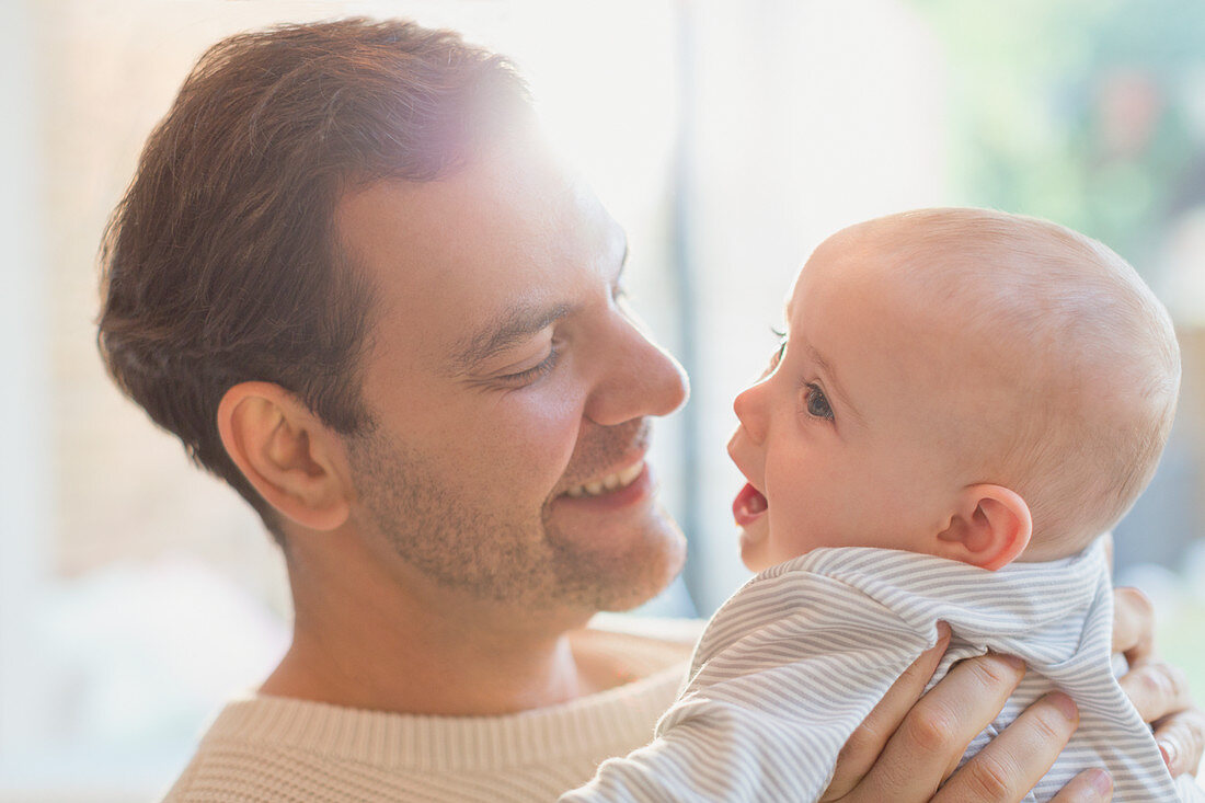 Affectionate father holding baby son