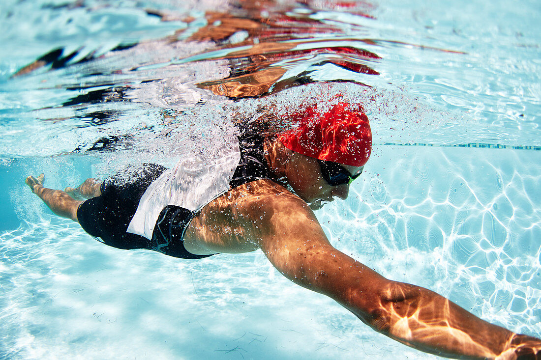 Male swimmer athlete swimming underwater