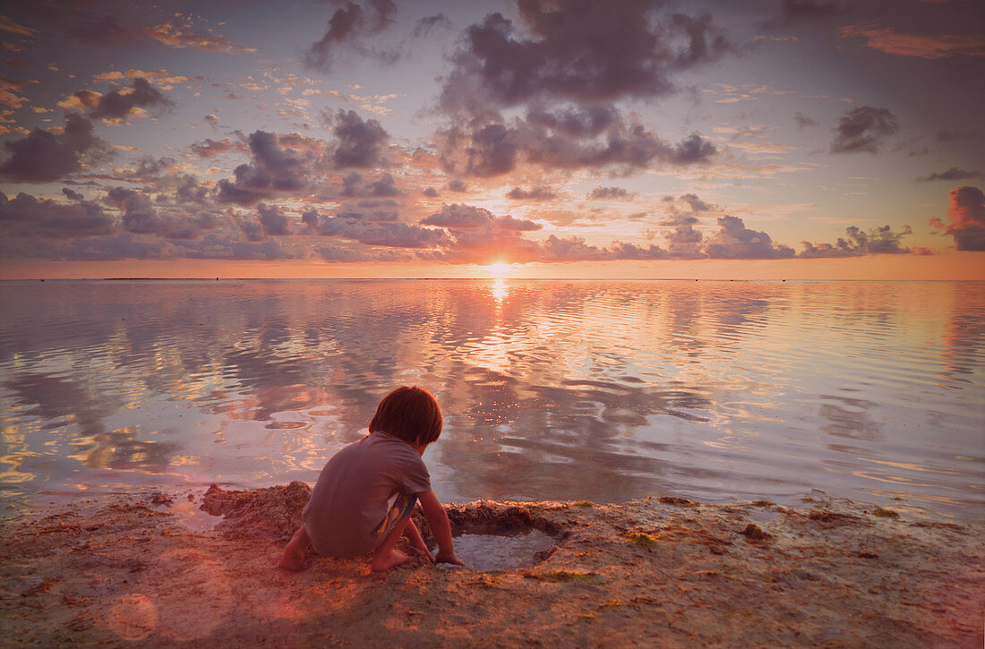 Boy playing in wet sand