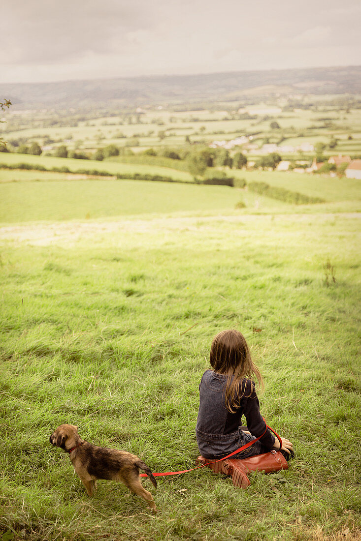 Girl with puppy dog in countryside