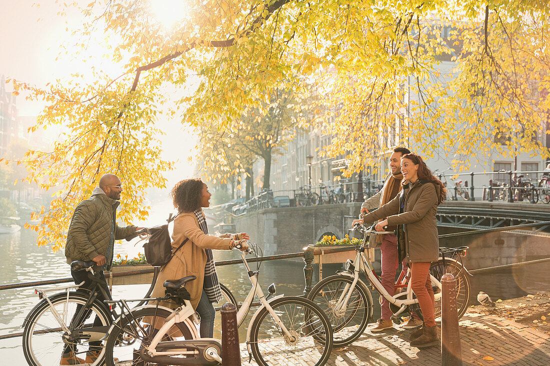 Friends with bicycles along autumn canal