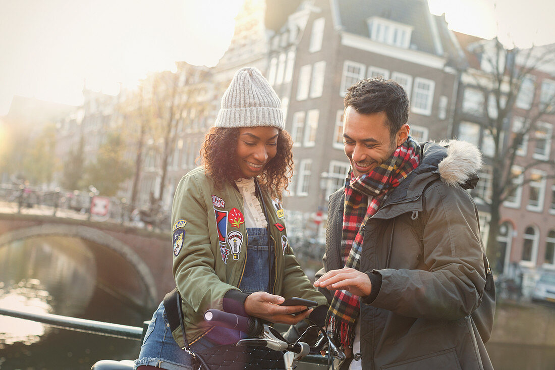 Young couple with bicycle using cell phone