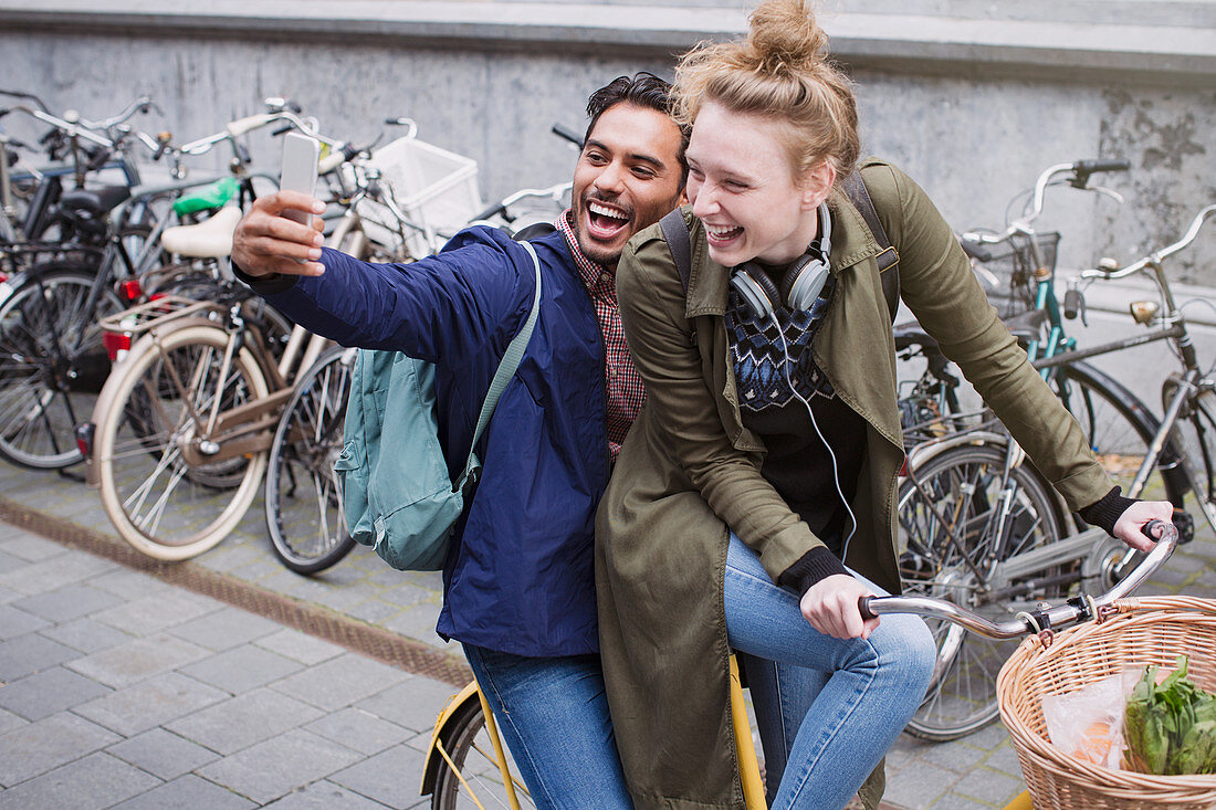 Young couple taking selfie on bicycle