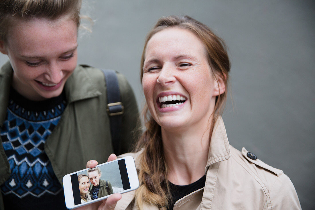 Laughing young women showing selfie