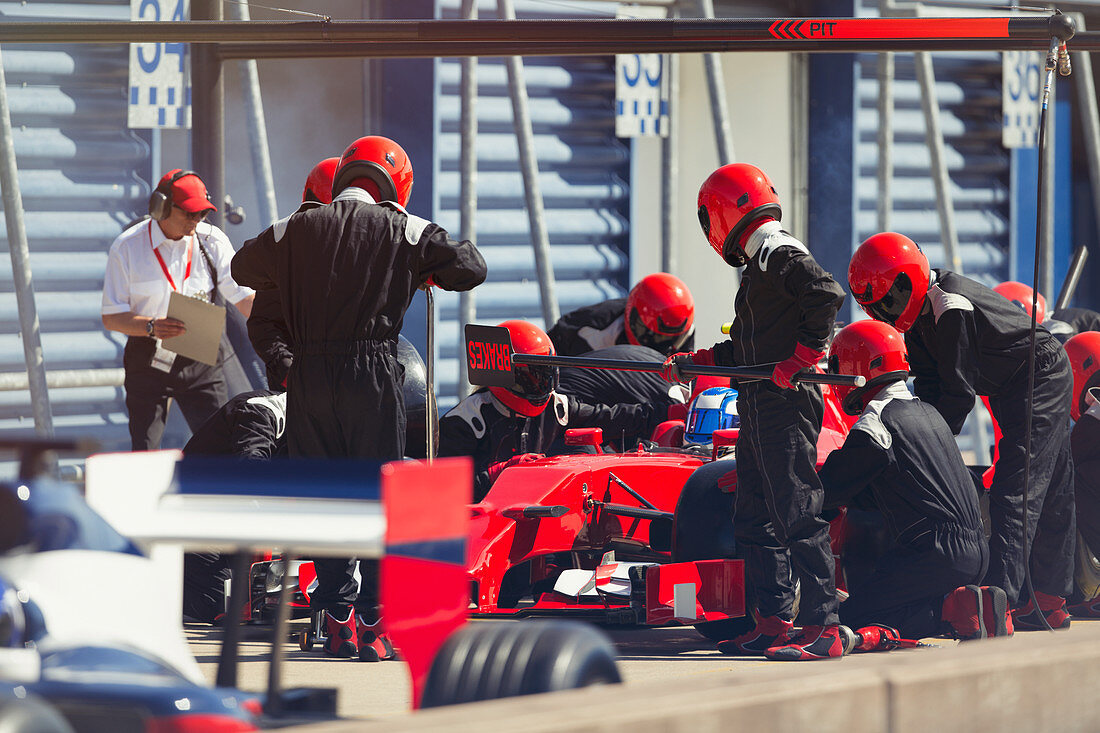 Pit crew replacing tires on formula one race car