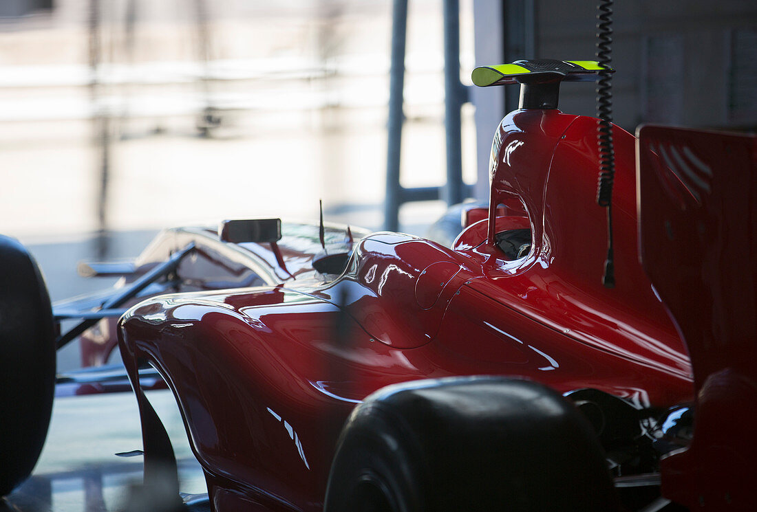 Red formula one race car in repair garage