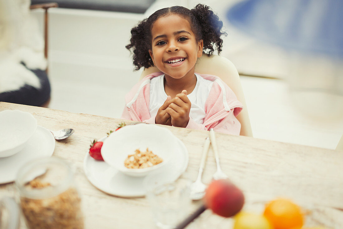 Portrait girl eating breakfast at table