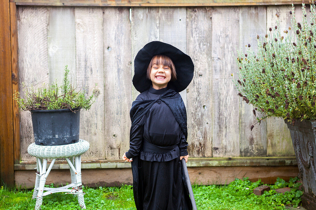 Portrait girl wearing witch costume in garden