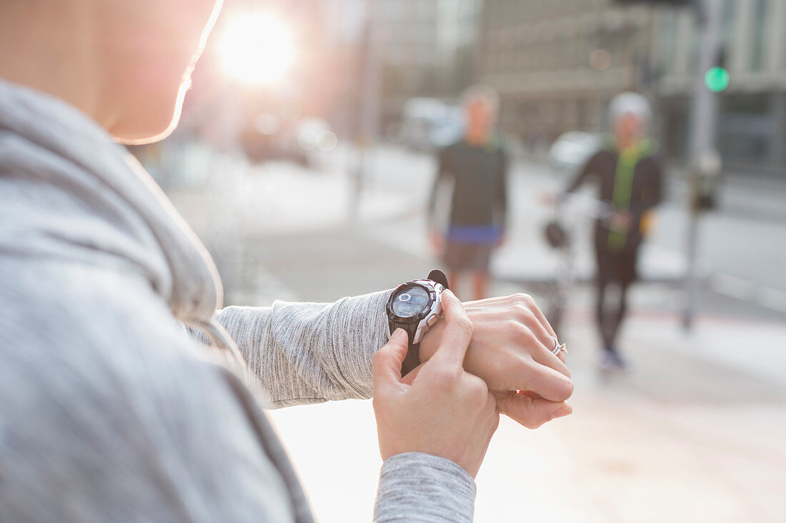 Female runner checking smart watch on street