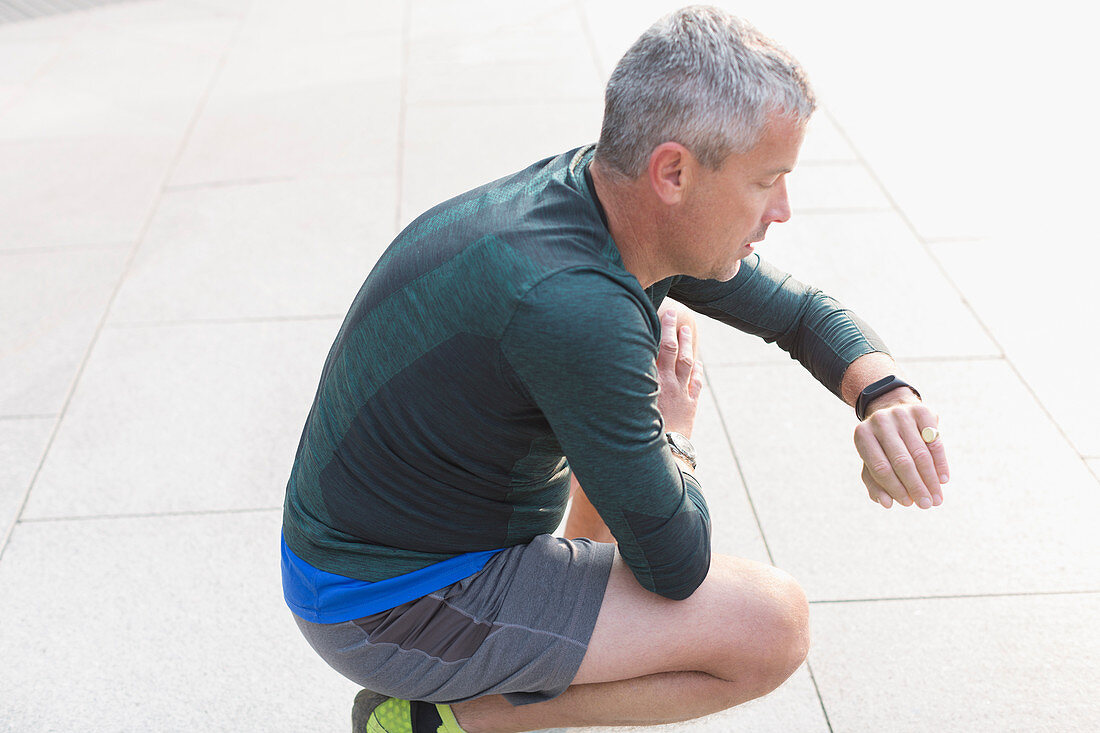 Male runner resting, crouching