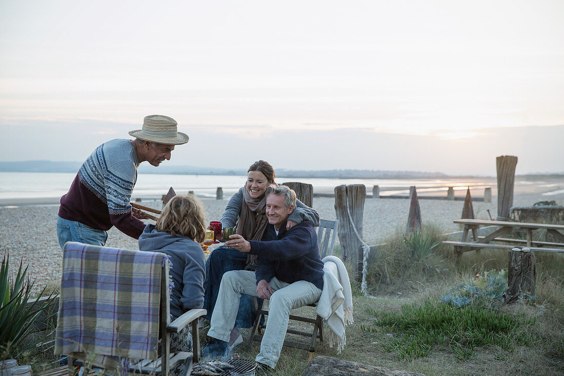 Mature couples barbecuing, drinking wine