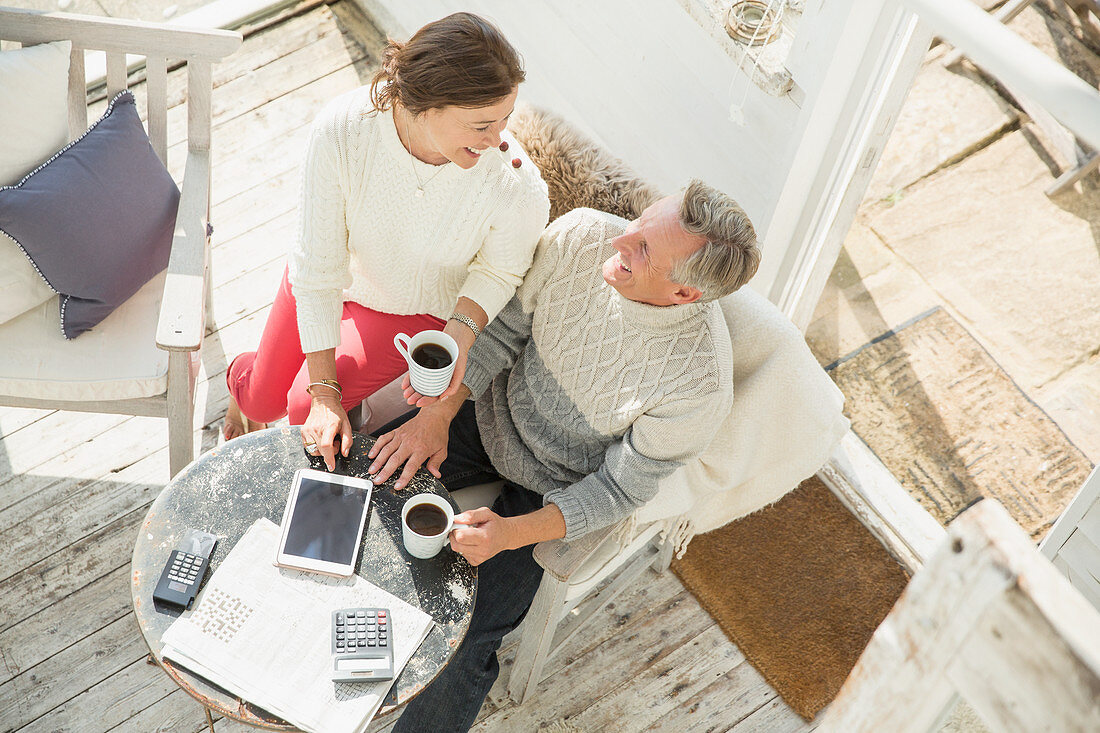 Mature couple drinking coffee and using tablet