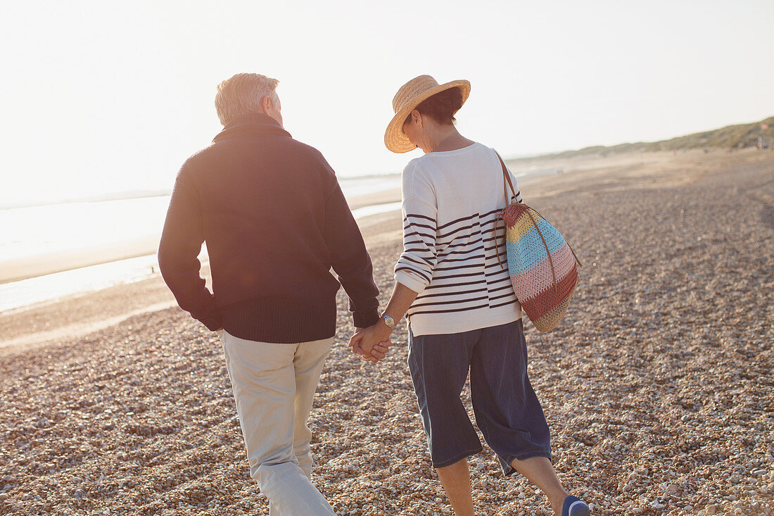 Affectionate mature couple holding hands walking