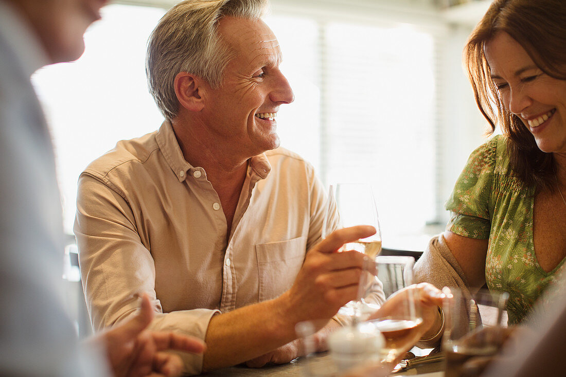 Smiling mature couple drinking wine, dining table