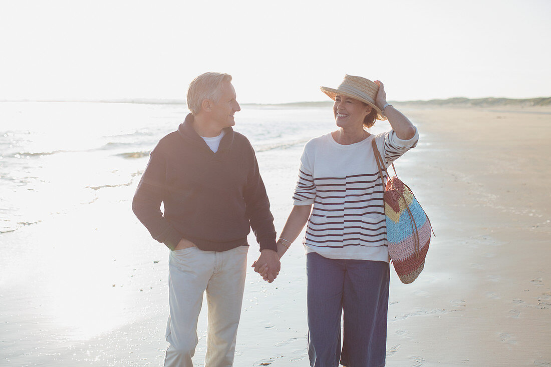 Smiling mature couple holding hands and walking