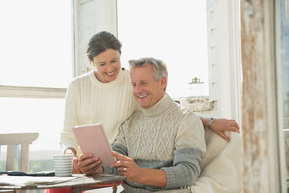 Smiling mature couple using tablet