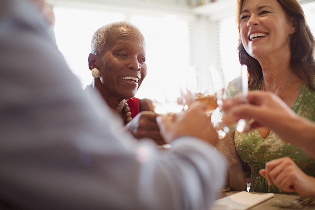 Smiling mature women drinking wine, dining