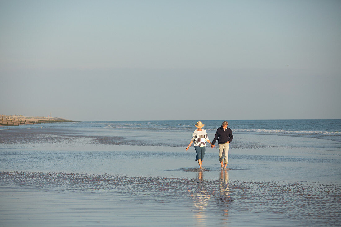 Mature couple holding hands walking