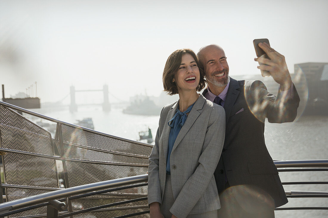 Business couple taking selfie, London, UK