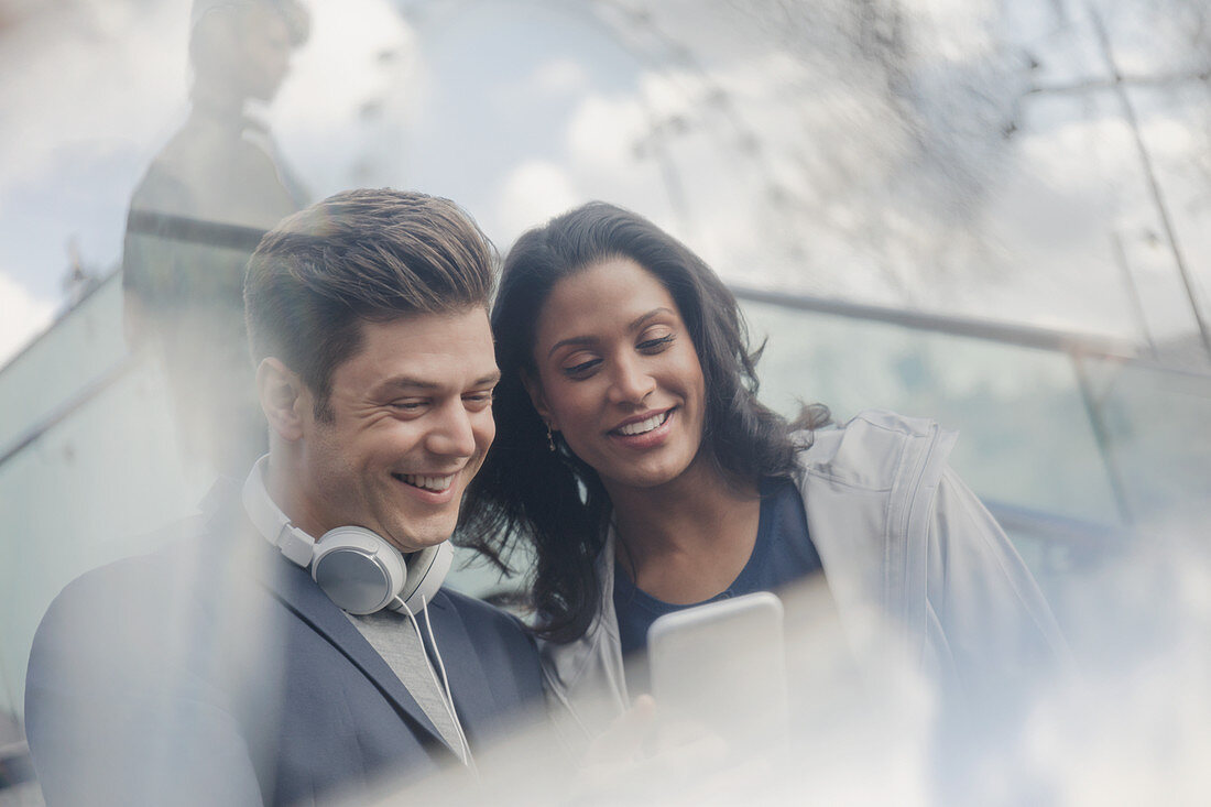 Couple with headphones using cell phone