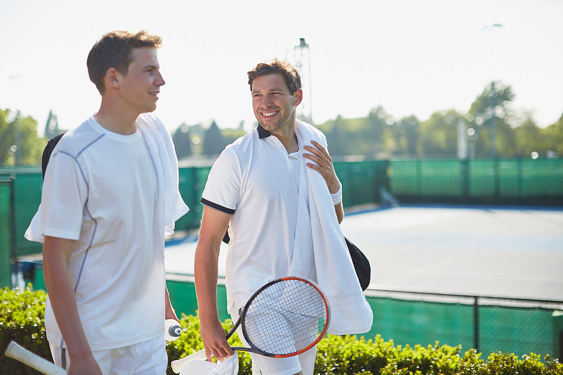 Smiling tennis players walking