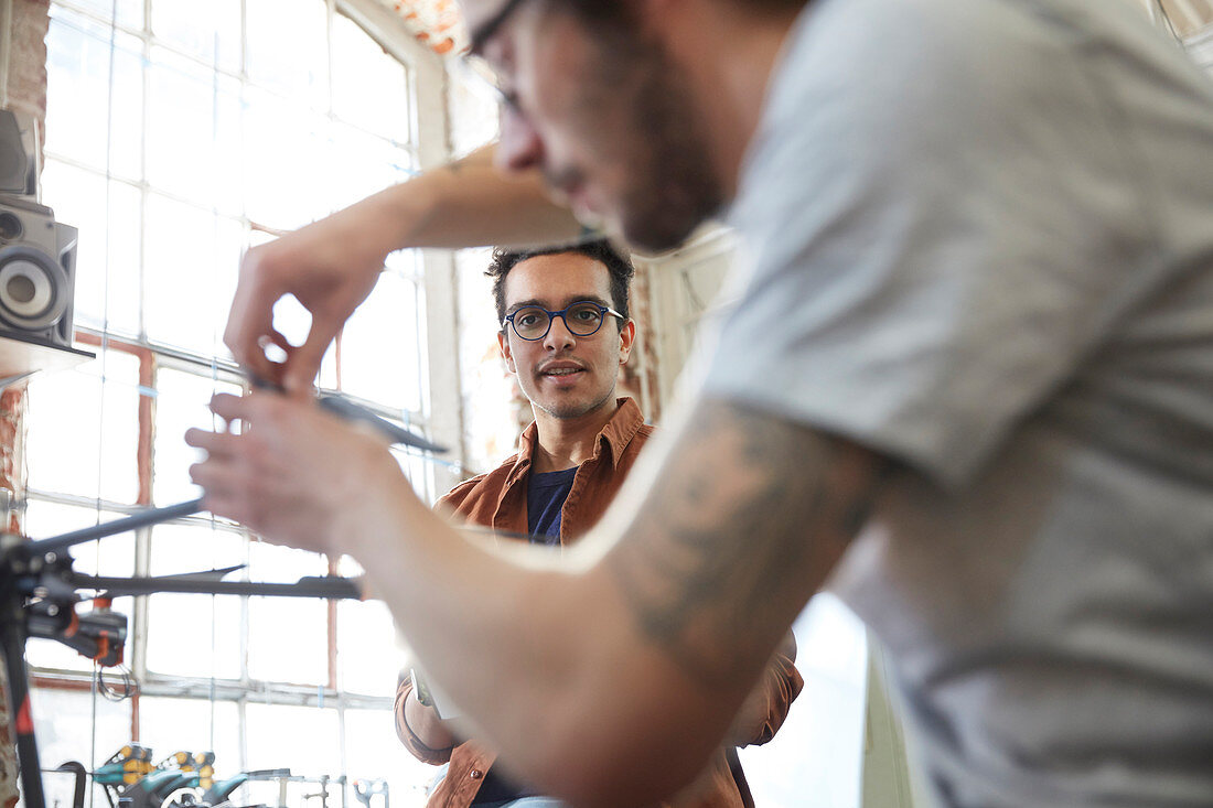 Male designers assembling drone in workshop