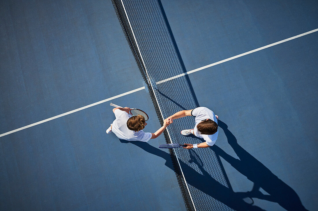 Overhead view tennis players handshaking at net