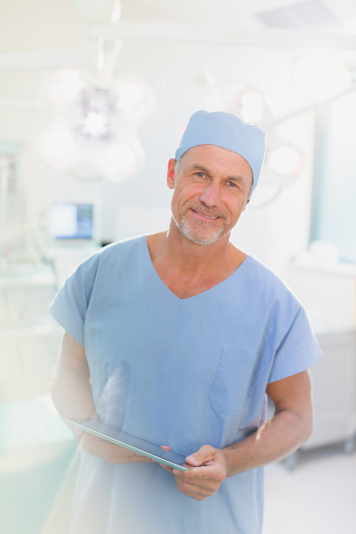 Portrait male surgeon using digital tablet