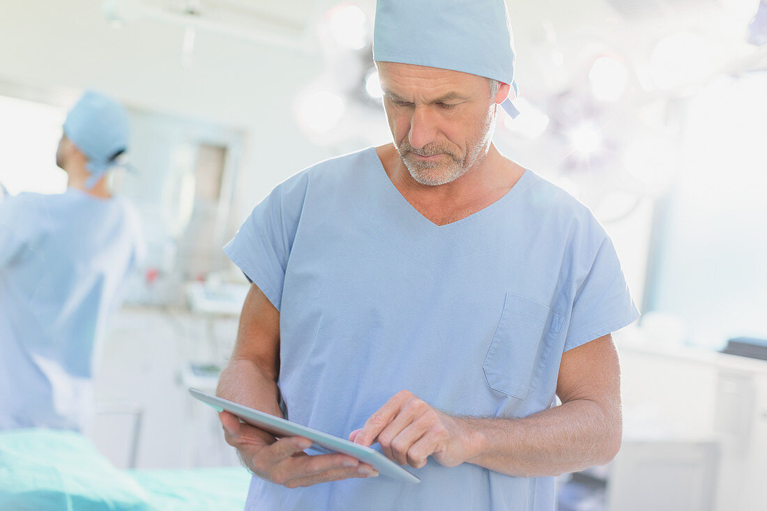 Male surgeon using digital tablet