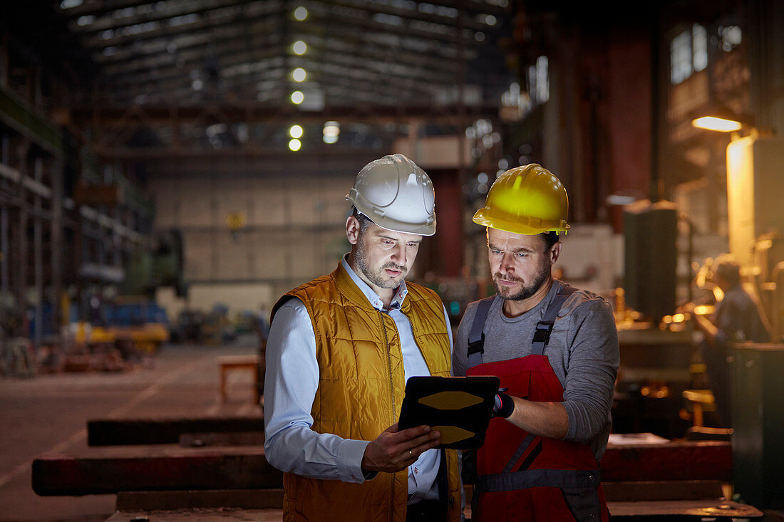 Male foreman and engineer using tablet