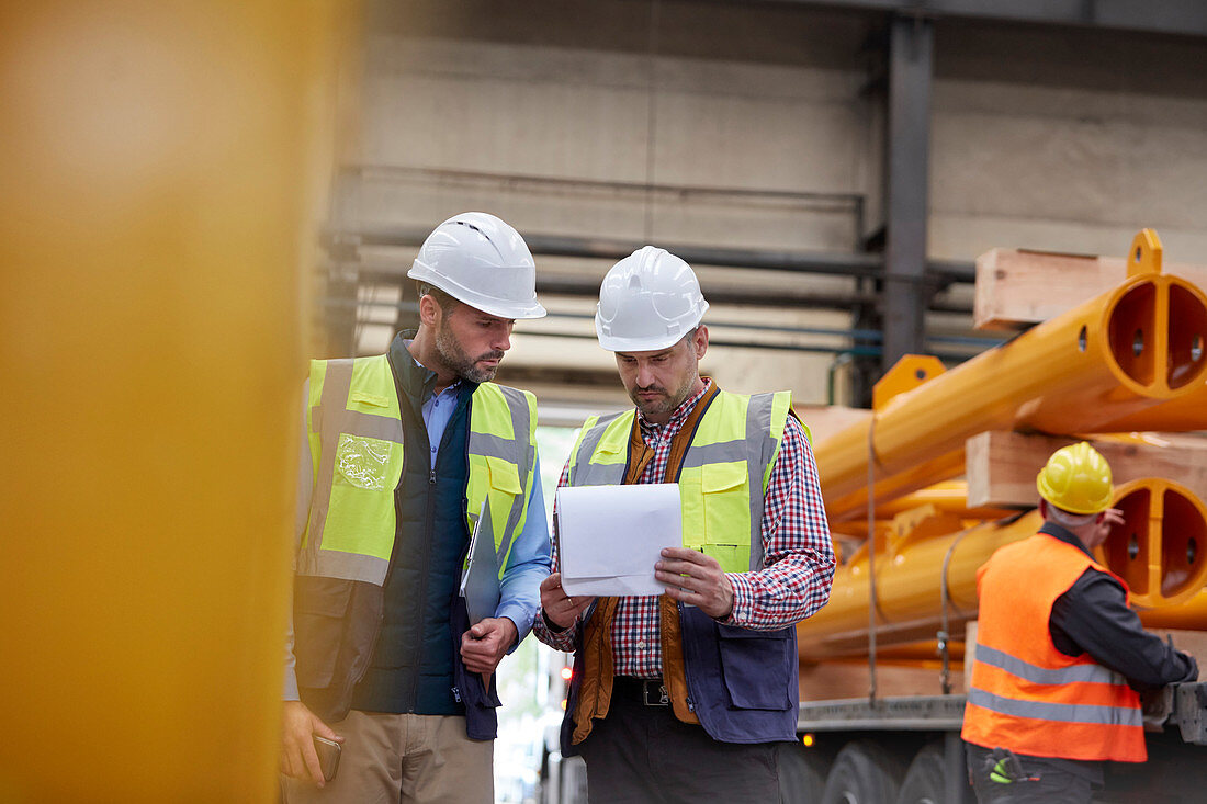 Male foreman and worker reviewing paperwork