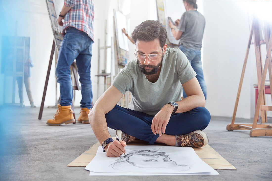 Male artist sketching on floor