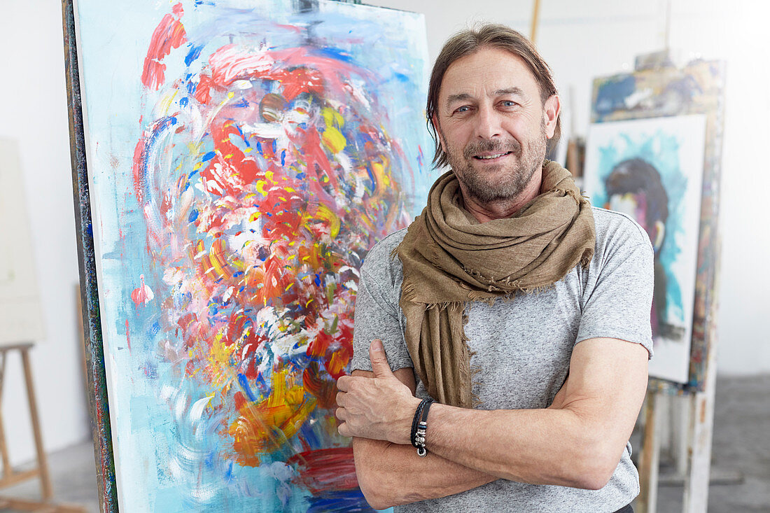 Portrait artist standing at abstract painting