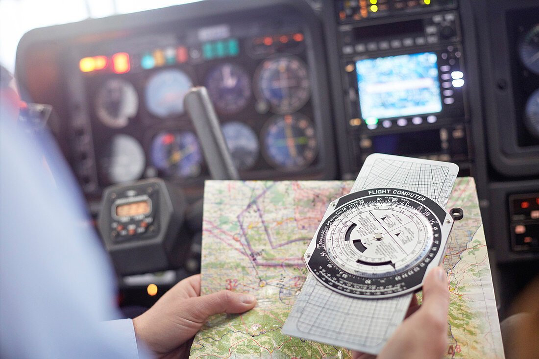 Pilot checking navigational map and compass
